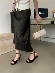 Detailansicht schwarzer High Heel Sandalen mit feiner Schleife und zartem Fesselriemen.