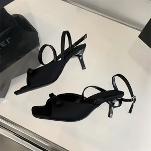 Detailansicht französischer schwarzer Slingback-Sandalen mit Absatz und süßer Schleife.