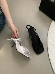 Detailansicht französischer High-Heel-Sandalen mit feiner Schleife und Knöchelriemen.