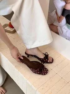 Elegantes sandalias marrones de lunares con lazo y tacón kitten, chic mules de verano.