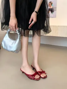 Vista detallada de elegantes mules con tacón de gatito de lunares rojos, sandalias punta cuadrada.