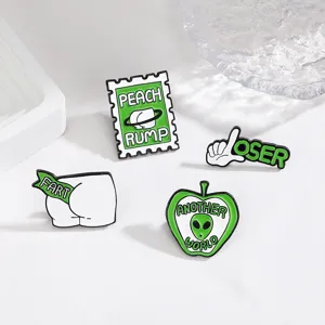Primer plano detallado de broches esmaltados verdes creativos con divertidos diseños de sellos.
