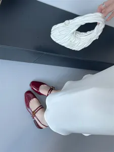 Gros plan sur des escarpins Mary Jane en cuir vernis rouge vin a bout carre et brides.