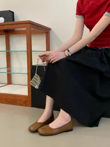Detail shot showing retro flat mary jane shoes paired with an elegant outfit in a modern setting.