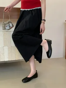 Detailed view of women's vintage flat shoes paired with chic black outfit and metallic bag.