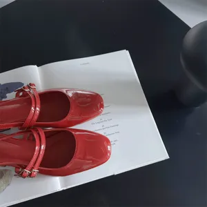 Gros plan détail de chaussures Mary Jane à talons carrés en cuir verni rouge vif.