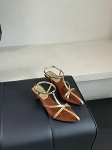 Nahaufnahme von spitzen Slingback-Sandalen aus braunem Wildleder mit eleganten Goldriemen.