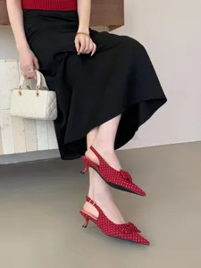 Detail view of red polka dot pointed slingback kitten heels with elegant bow for women.