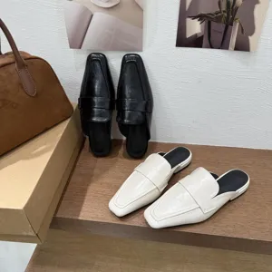 Vista dettagliata di eleganti sabot da donna con punta quadrata in classico bianco e nero.