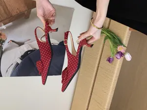 Red polka dot pointed toe slingback kitten heels with bow detail, close-up shoe view.