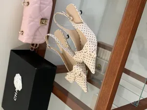 Detailed view of stylish polka dot slingback kitten heels featuring an elegant bow decoration.