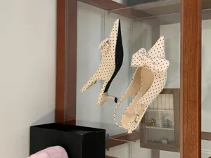 Detail shot of beige polka dot slingback low heel shoes featuring a large front bow.