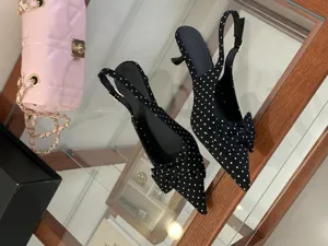 Black polka dot slingback kitten heels with elegant bow detail, stylish pointed toe women shoes.