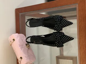 Black and white polka dot slingback pumps with bow detail, elegant women's pointed toe shoes.