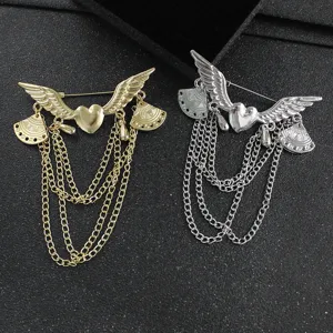 Detailed view of trendy angel wings heart tassel brooch, metallic creative jewelry design.