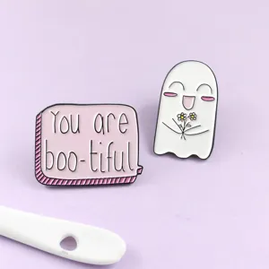 Primer plano de un lindo fantasma y broche esmaltado con letras de burbuja rosa.