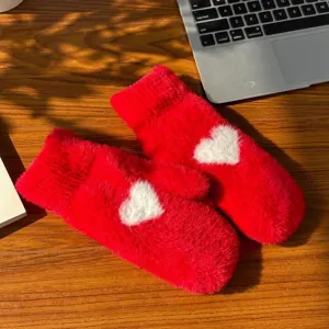 Women's red plush winter mittens featuring a cute white heart pattern, thick warm cozy gloves.