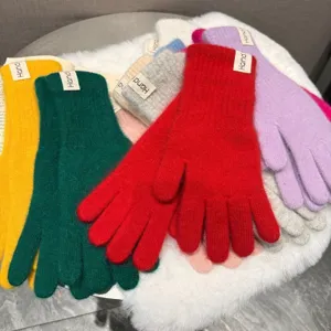 Nahaufnahme von weichen Plüsch-Strick-Winterhandschuhen in bunten Farben, warm und kuschelig.