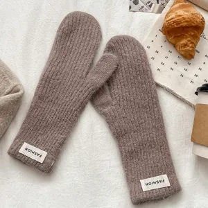 Cozy winter knitted mittens detail, warm woolen fleece texture, elegant brown cold weather gear.