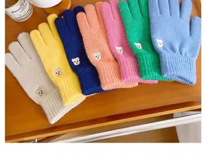 Vista detallada de guantes de invierno de punto bordados con osito, cálidos y táctiles.