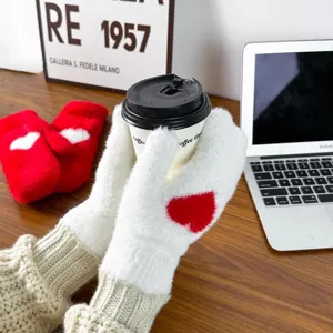 Plush winter mittens detail showcasing soft white faux fur, red heart pattern, and cozy ribbed cuffs.