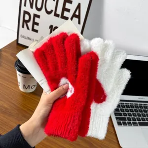 Close-up of cozy red and white plush winter mittens, thick warm fleece fabric detail.