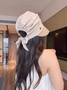 Detailed view showing the back bow tie and pleated design of women's straw sun hat.