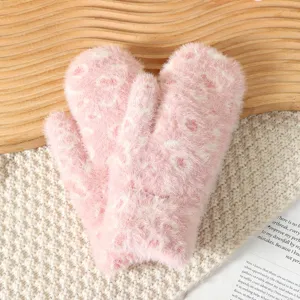 Close-up of cozy pink fluffy leopard print winter mittens detail, soft plush fabric texture.