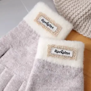 Detail view of women's winter thick knit gloves with plush cuffs and stylish lace label.