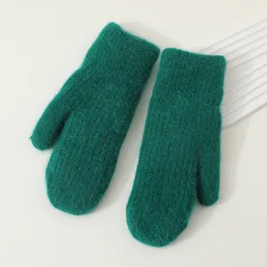Close-up detail of the plush knitted green mittens, showing soft fuzzy texture and cozy winter fabric.