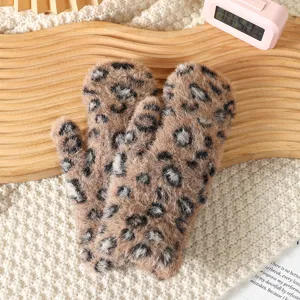 Close-up detail of soft brown leopard plush winter mittens showing cozy fluffy fabric texture.