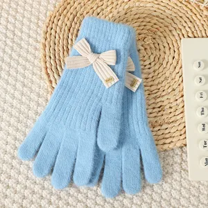 Light blue knitted gloves detail, showcasing cute cream bow decoration and cozy winter fabric.