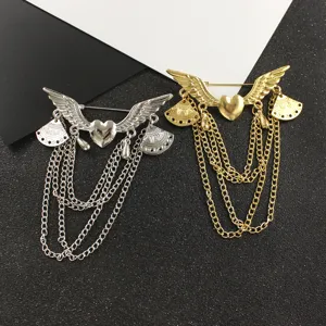 Detailed shot of stylish heart angel wings metal chain tassel brooch in silver and gold