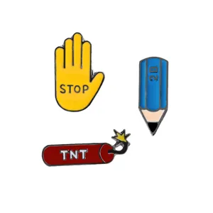 Close-up detail of cartoon alloy enamel lapel pins featuring stop sign, pencil and bomb.