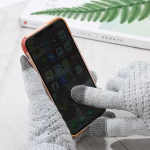 Close-up of gray knit touchscreen gloves being used on a smartphone, showing detailed texture.