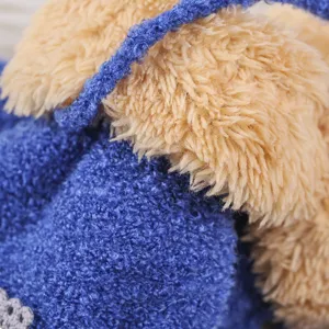 Close-up detail of children winter plush gloves, soft coral fleece texture, blue and camel.