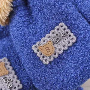 Close-up of warm coral fleece kids knit glove with cute bear patch and love text for winter.