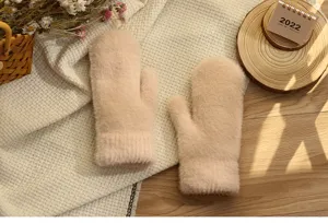 Detailopname van gezellige beige pluche winterwanten, dik warm gebreid materiaal.