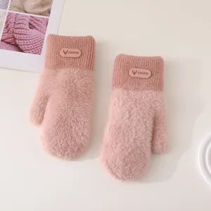 Close-up detail of winter plush knit mittens in soft pink, featuring fuzzy texture and patch.