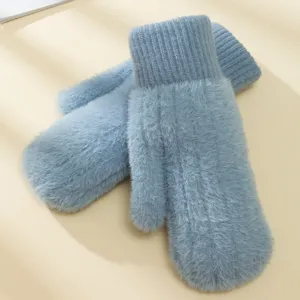 Primo piano di soffici guanti invernali in peluche azzurro chiaro, polsini in maglia.