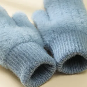 Primo piano dettagliato di morbidi guanti invernali in maglia soffice azzurri, caldi.