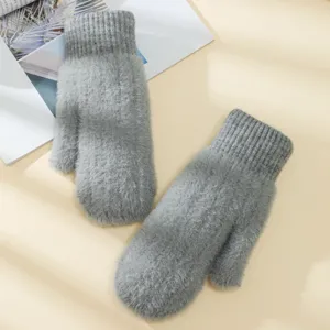 Dettaglio di soffici guanti in peluche invernali, guanti grigi caldi per uso quotidiano.
