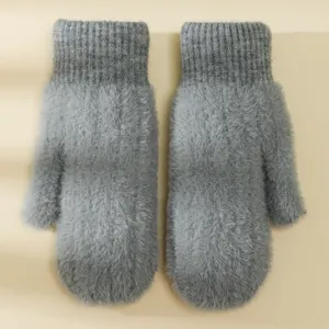 Primo piano di guanti invernali grigi e soffici con texture morbida e polsino in maglia calda.