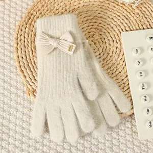 Cute bow knitted gloves detail view, warm winter accessory for women, soft cozy texture.