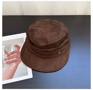Detail view of brown suede retro flat cap with chic pleats and cute metal heart charm.