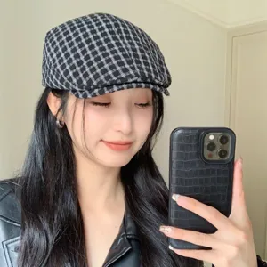 Dettaglio berretto a quadri, classico cappello piatto retrò indossato dalla modella, stile.