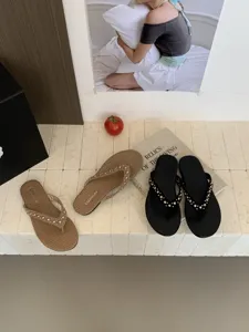 Detail van chique platte teenslipper met sprankelende metalen studs en textuur.