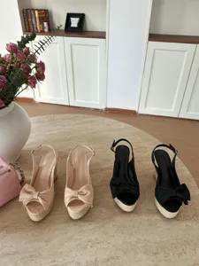 Vista dettagliata di sandali con zeppa espadrillas da donna con fiocco e tacco plateau.