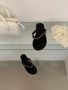 Platte damestenzetsandalen met chique gouden studs, stijlvol schoeisel voor zomerse dagen.