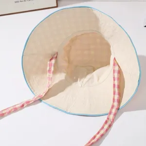 Gros-plan chapeau bob femme liens à carreaux roses, bord bleu et tissu léger et aéré.
